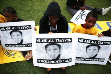 A group of children hold signs with Trayvon Martin pictured on them in Phoenix, on July 16, 2013.