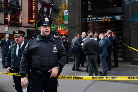 image: Uniformed and plainclothes police officers stand outside a New York subway station after a man was killed after falling into the path of a train, Dec. 3, 2012. 