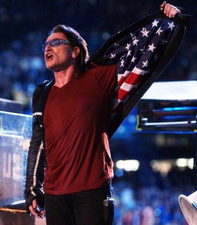Bono, lead singer of U2, shows an American flag lining in his jacket during the halftime show at Super Bowl XXXVI in the Superdome, New Orleans, La., on Feb. 3, 2002. 
