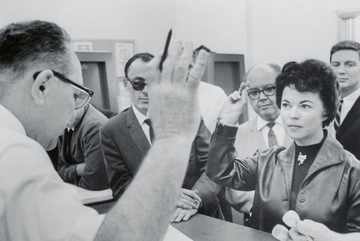 Shirley Temple Black raises her hand to be sworn in by Administrative Assistant James J. Sweeney (left) at the registrar's office at county courthouse in Redwood City, Calif., on Oct. 13, 1967. 